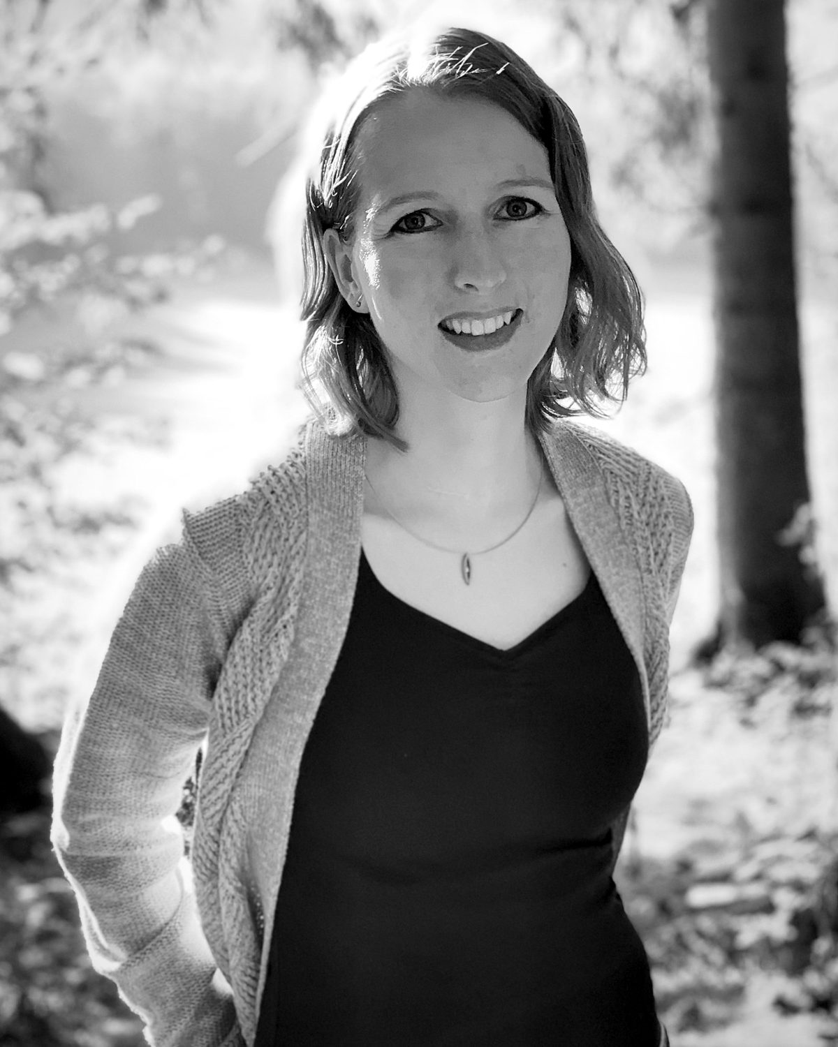 Tina Sulzenbacher, Grafik- und Webdesignerin von pixelschupfa, lächelnd im Grünen